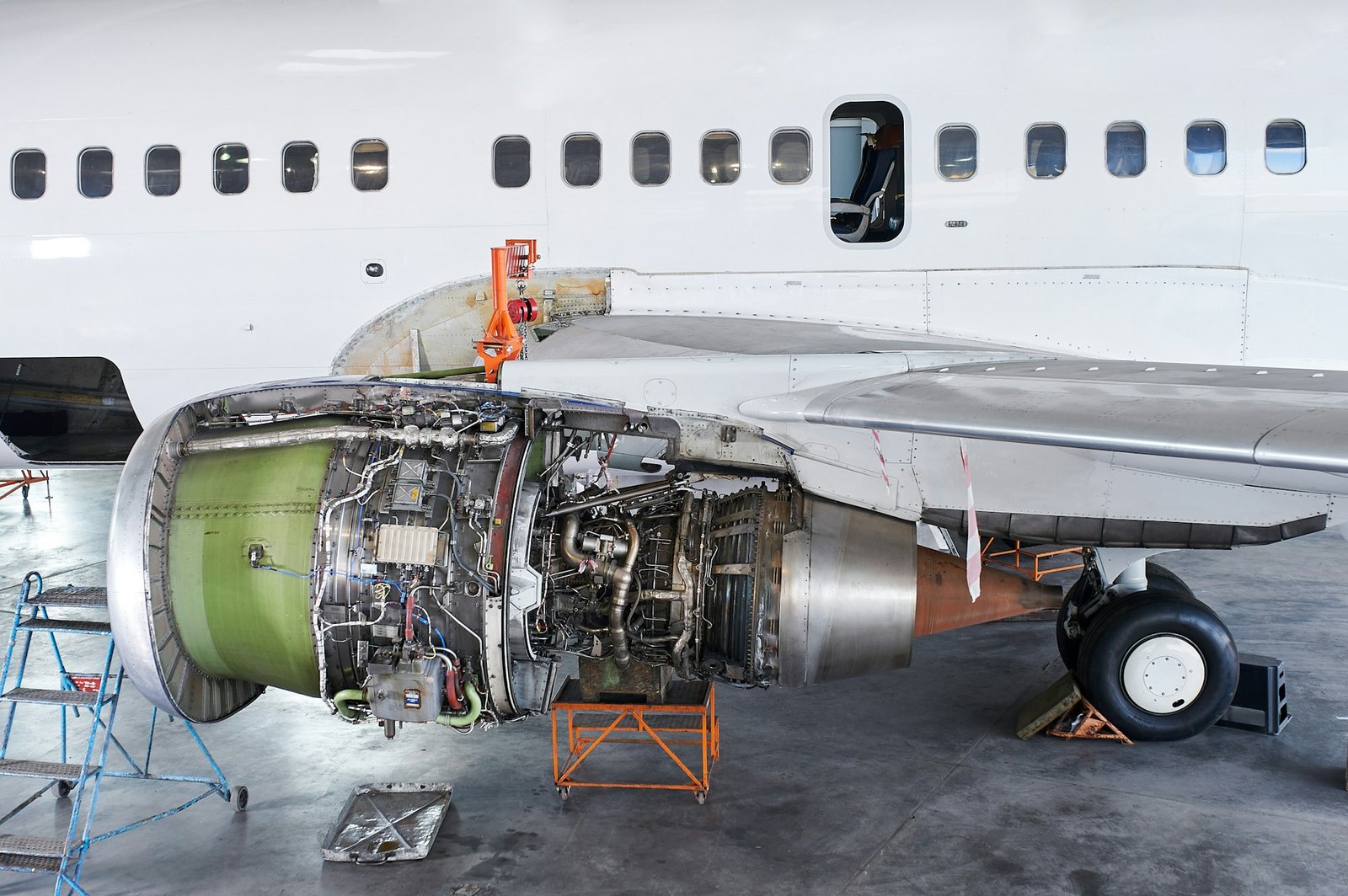 aircraft engine servicing - opened panels of a large engine of parked aircraft.